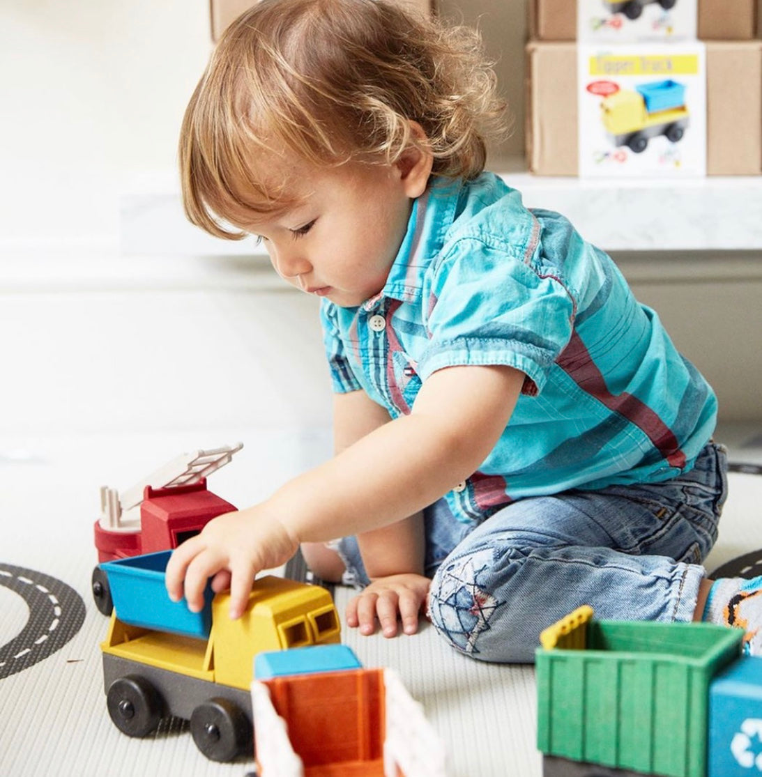 A preschooler plays with a Luke's Toy Factory Tipper Truck
