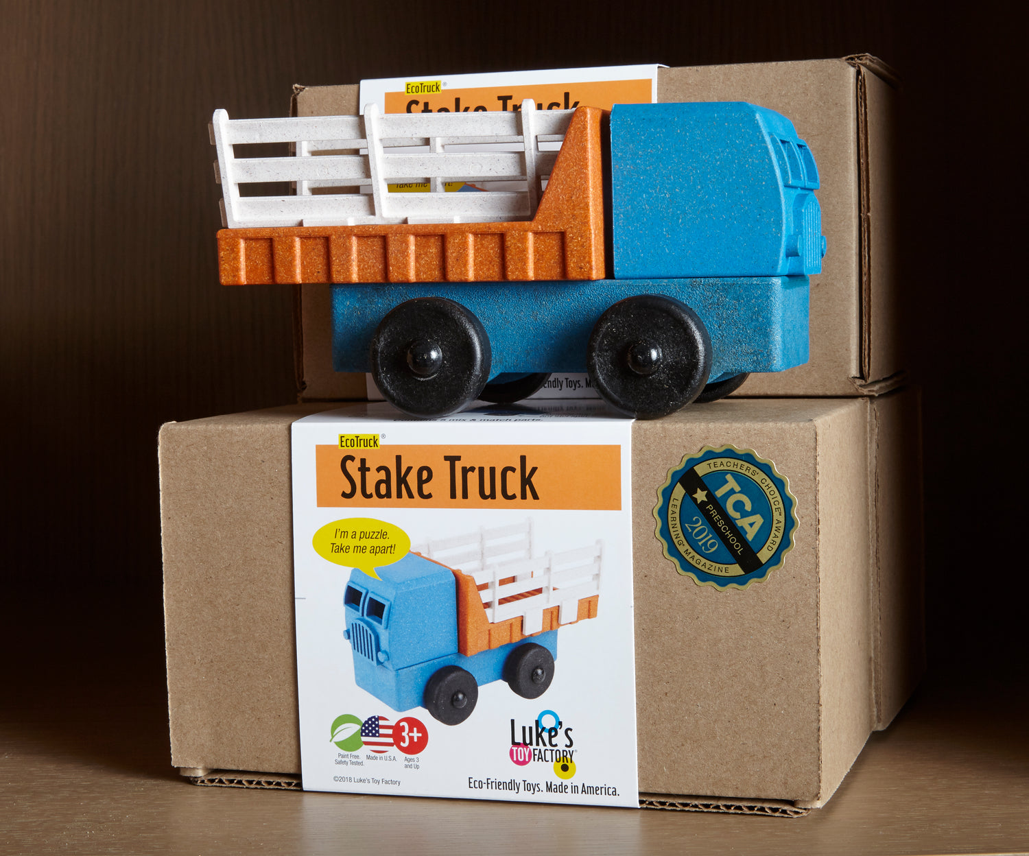 A preschool toy Stake Truck Toy sits on its cardboard box packaging on a gift store shelf