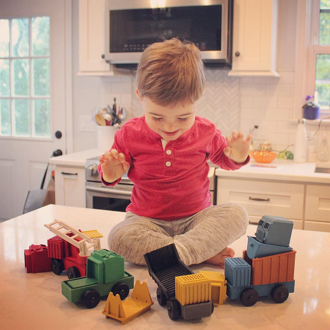 A preschool aged child delighted by his Luke's Toy Factory Trucks, educational truck toys