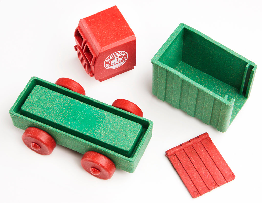 Set of toy truck parts including a green truck bed and red cab on a white background.