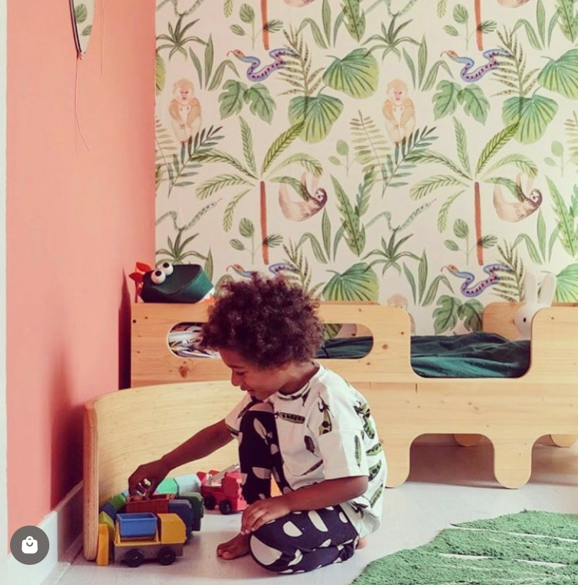 Child Playing with preschool toy trucks against a wall