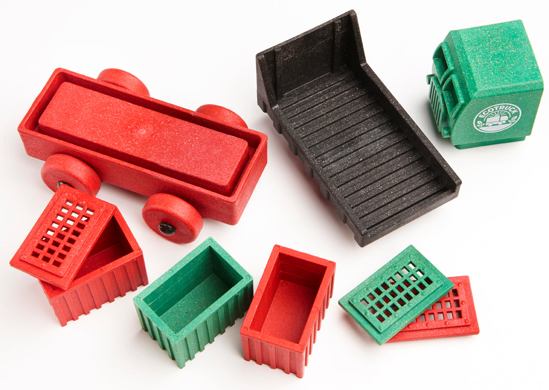 Set of toy truck parts including a red truck, black bed, and various green and red boxes on a white background.