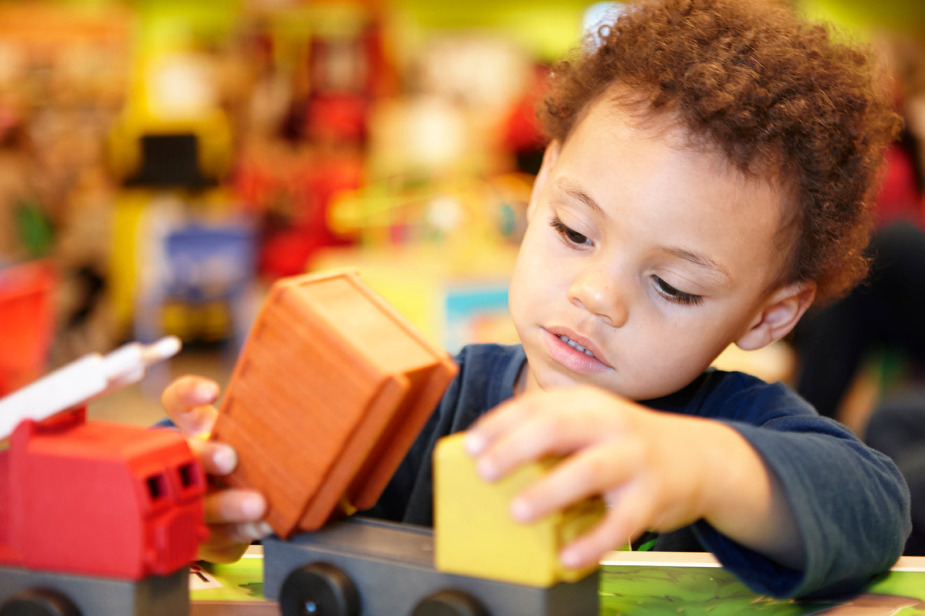 A preschooler assembles a Luke's Toy Factory toy truck