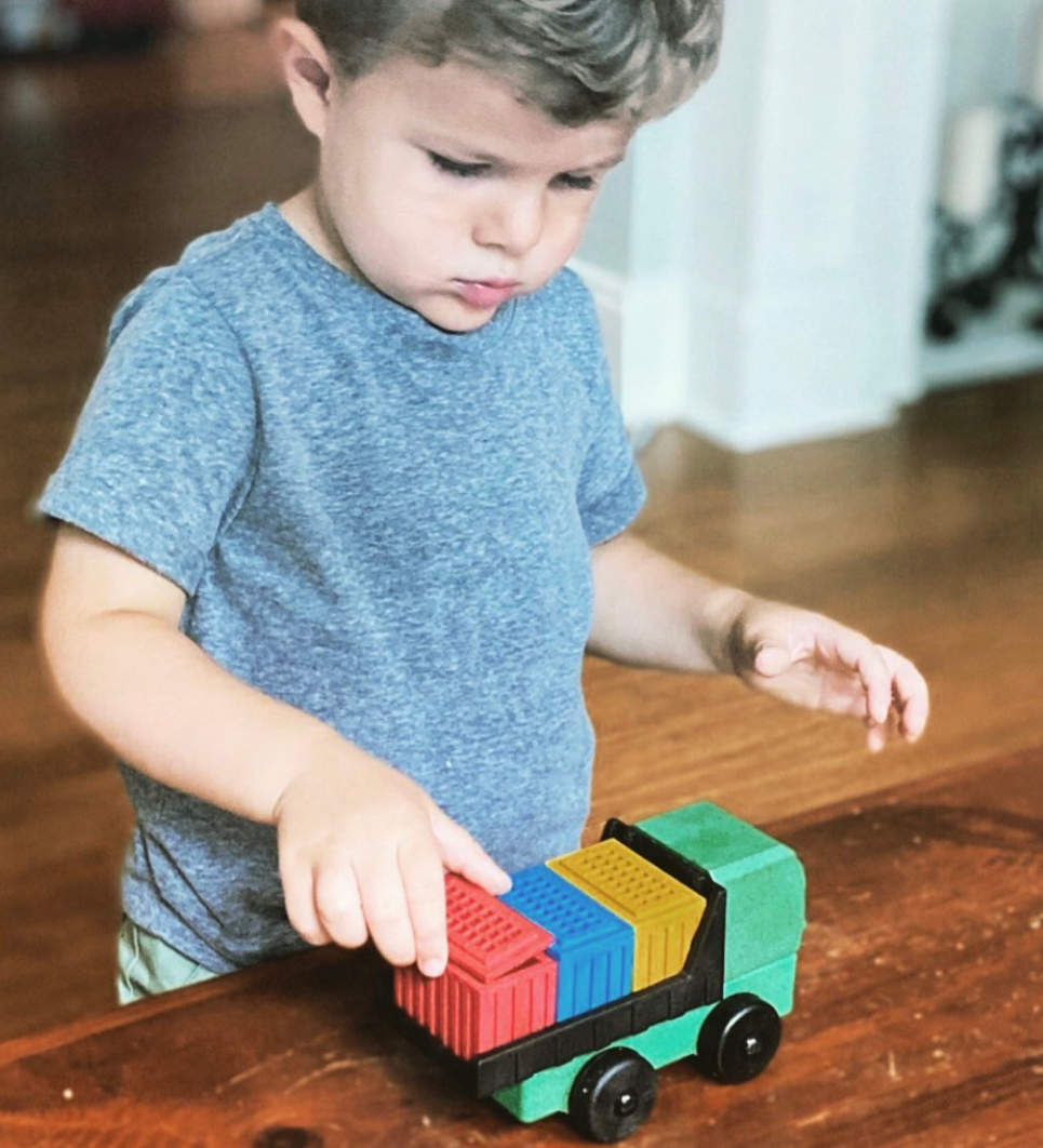 Preschool aged Child playing with Luke's Toy Factory Cargo Truck toy