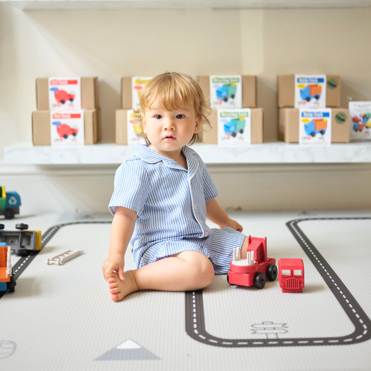 Toy Firetruck on floor with truck toys on shelf in toy store